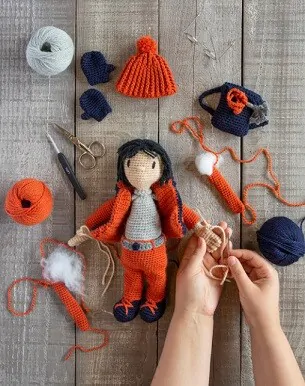 amigurumi doll in orange clothes