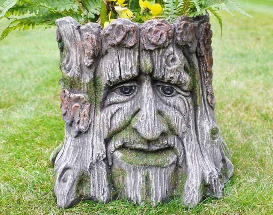 resin tree stump planter planted with ferns and flowers