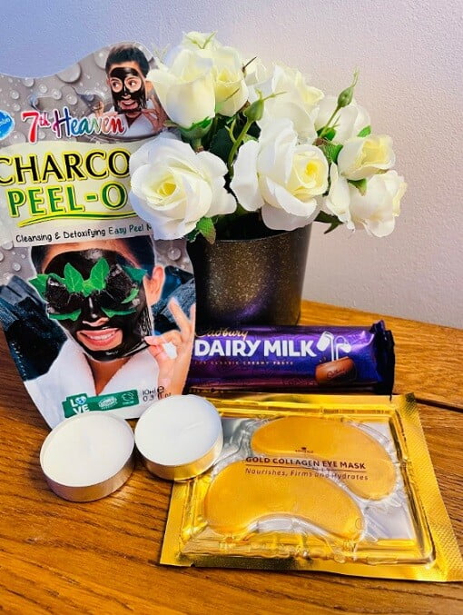chocolate, face mask, eye mask, hot chocolate and candles in a letterbox pamper set