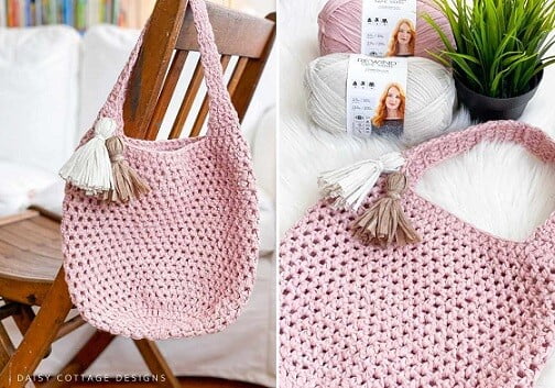 Smaller crocheted market tote bag in pin hanging off the back of a wooden chair
