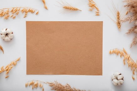 brown scrap paper on a table surrounded by ears of corn