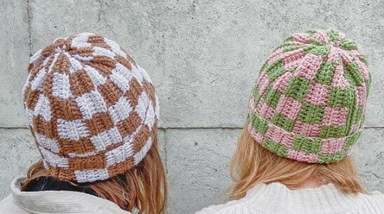 two women face away wearing checkerboard beanie hats