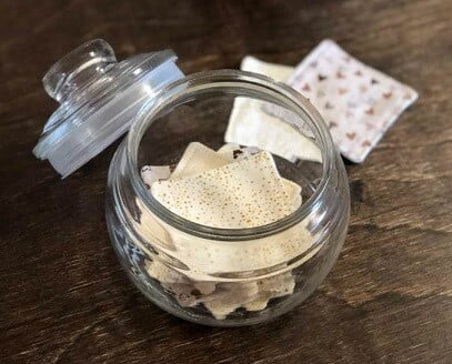glass jar holding re-usable make-up remover pads made from scrap fabric for an eco project