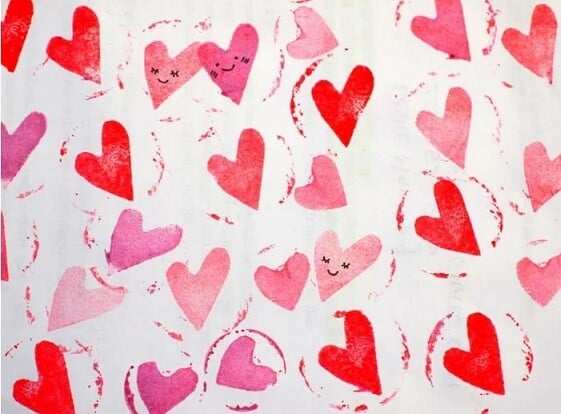 scrap paper stamped with hearts made from a wine cork stamp