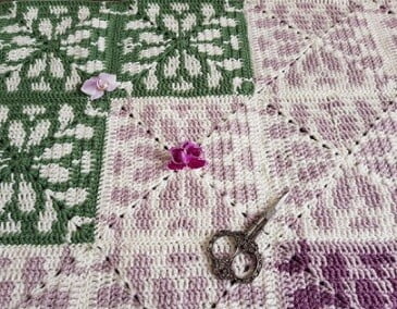 green, white and grey tapestry squares make up this blanket