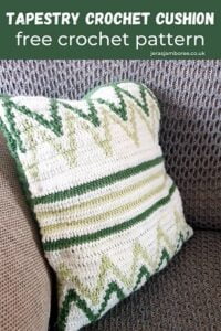 tapestry crochet cushion cover in white, dark green and light green on a grey sofa