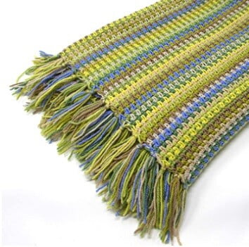 crocheted blanket in violet and green with tassels