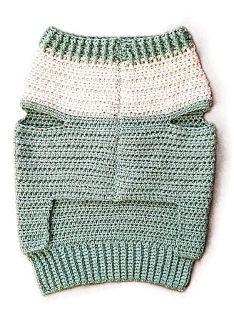the finished crochet dog sweater is laid flat with the underside on top showing the seam