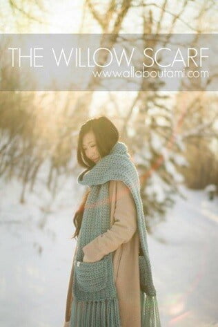 a woman is standing in a snowy landscape wearing a coat and crocheted scarf