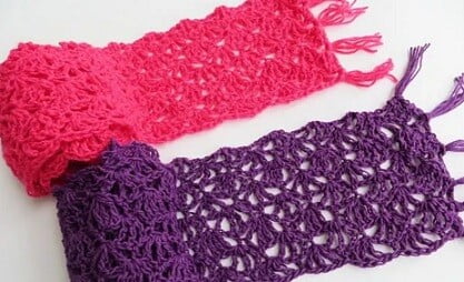 Two crochet lacy scarves, one in deep pink and one in purple