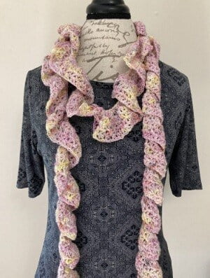 crochet ruffle scarf is styled on a mannequin