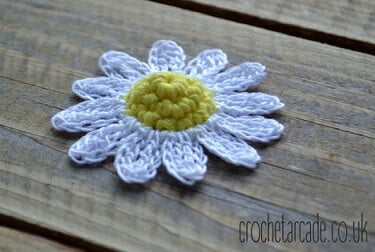 3d crochet daisy on a wooden board