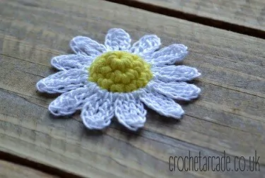 3d crochet daisy on a wooden board