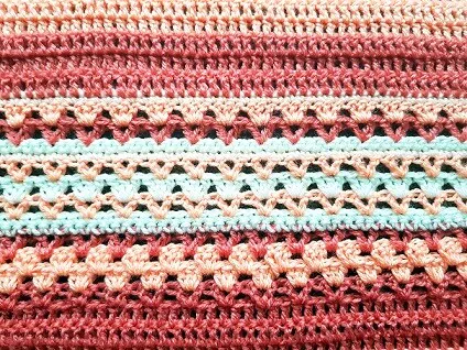 close up of the tangerine dreams baby blanket to see the detail of the crochet stitches