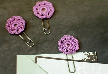 3 purple crochet flowers attached to paper clips