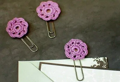 3 purple crochet flowers attached to paper clips