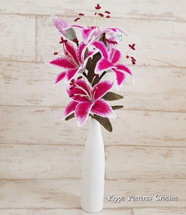stargazer lily crocheted in pink displayed in a white vase