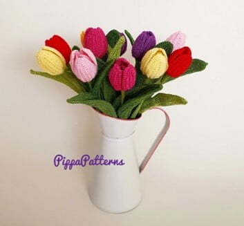 Red, pink, yellow and mauve crocheted tulips in a white jug