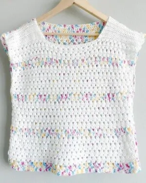 granny stripe crochet top in white with stripes of multi colour hanging on a coat hanger