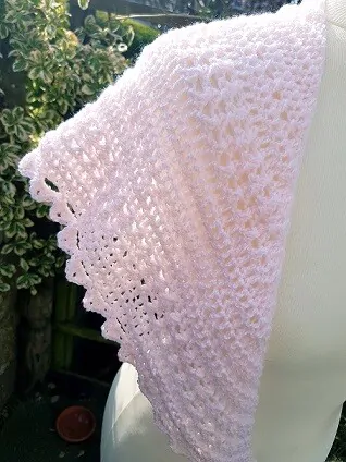 crochet shawl in pink close up of shoulder