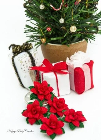 The base of a Christmas tree with wrapped presents and crocheted poinsettias