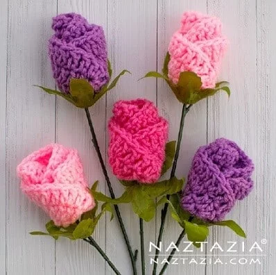 5 crochet roses in different pinks and purple made from folding over the crochet fabric using the origami technique