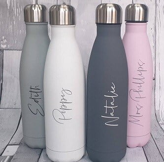 4 personalised water bottles in shades of grey, white and pink