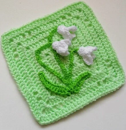 granny square with a crochet snowdrop embellishment 