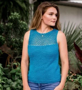 a woman is staring away from the camera and wearing a blue crochet top with jeans