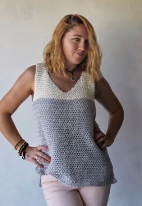 woman wearing a crochet tank top in white and grey and white jeans