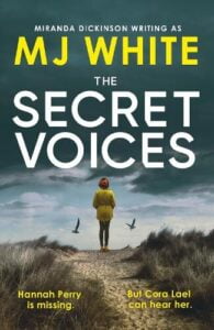 book cover for The Secret Voices by M J White. A woman wearing a yellow coat, leggings and a wooly hat walks away from the viewer over a wooded path