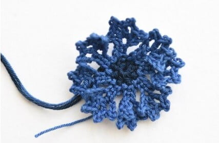 crocheted cornflower in different shades of blue