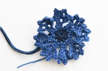 crocheted cornflower in different shades of blue
