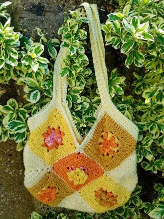 granny square tote bag hanging on ivy