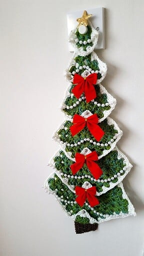 crochet christmas tree made from granny squares with bows and bells