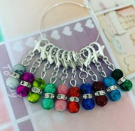 Different coloured stitch markers in the shape of balls of yarn