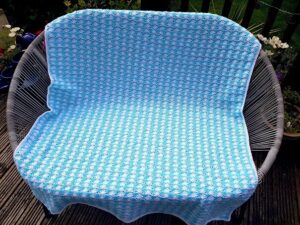 turquoise and white baby blanket in a shell pattern