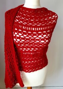 crocheted shawl in red styled on a mannequin