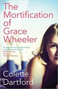 book cover for The Mortification of Grace Wheeler. A young woman is laying on her front with her legs in the air behind her