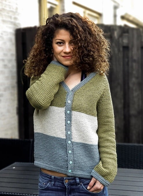 a woman is wearing jeans and a cardigan made from Tunisian crochet