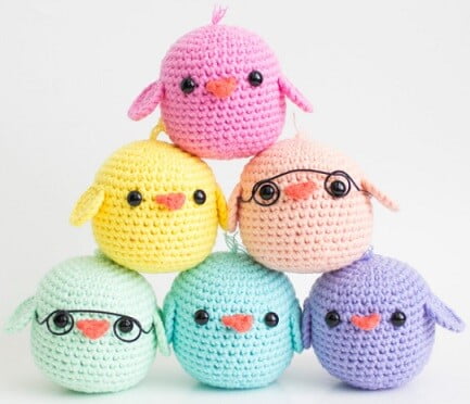 A pyramid of small chicks crocheted in pastel colours