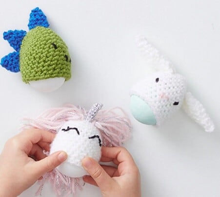 A dinosaur, bunny and unicorn egg covers