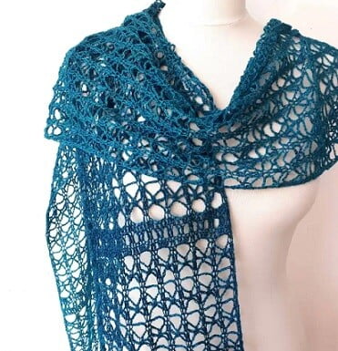 A delicate lacy scarf is styled around the shoulders of a mannequin