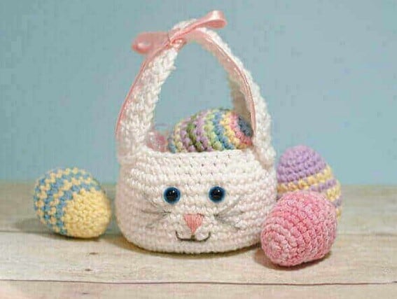 Crocheted basket with the ears made into a handle and a bunny face embroidered on one side