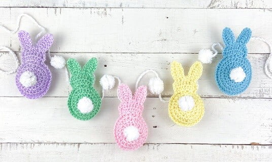 the back of 5 bunnies with fluffy tails strung together to form a garland