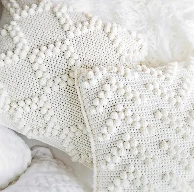 close up of bobble stitches creating diamonds and arrows on a pillow cover