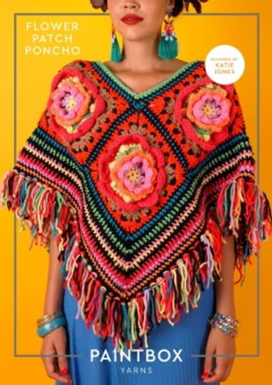 A woman is wearing jeans and a flower granny square poncho