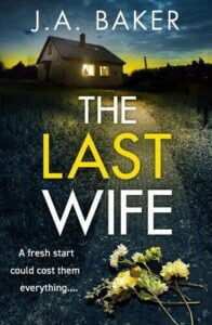 Book cover for The Last Wife by J A Baker. It is dusk and a path going up an incline has crushed flowers on. Further up the incline a house standing on its own has lights shining out