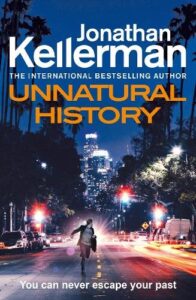 book cover Unnatural History by Jonathan Kellerman. A man is running down the middle of a road on a high street at night carrying a briefcase