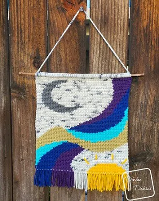 Wall hanging crocheted using the intarsia technique 'painting' a picture of a landscape with the moon